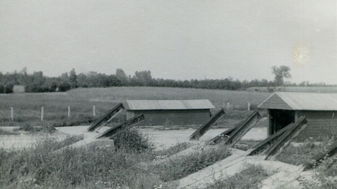 Een historische foto van een tankkering van losse betonblokken en spoorstaven