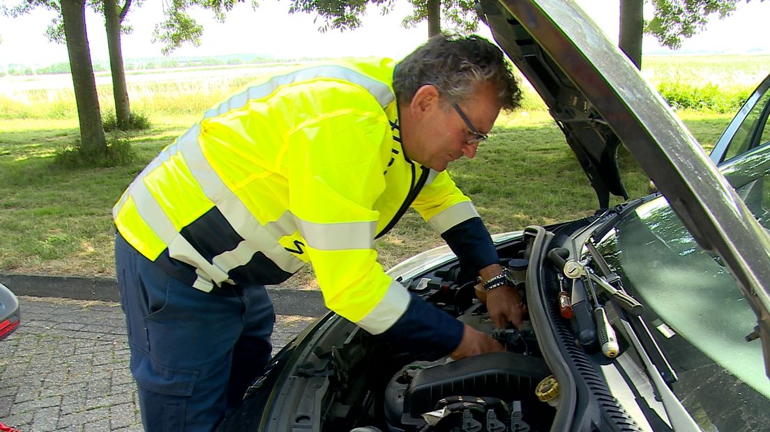 Wegenwachter Jan Saarloos repareert een auto bij Rilland