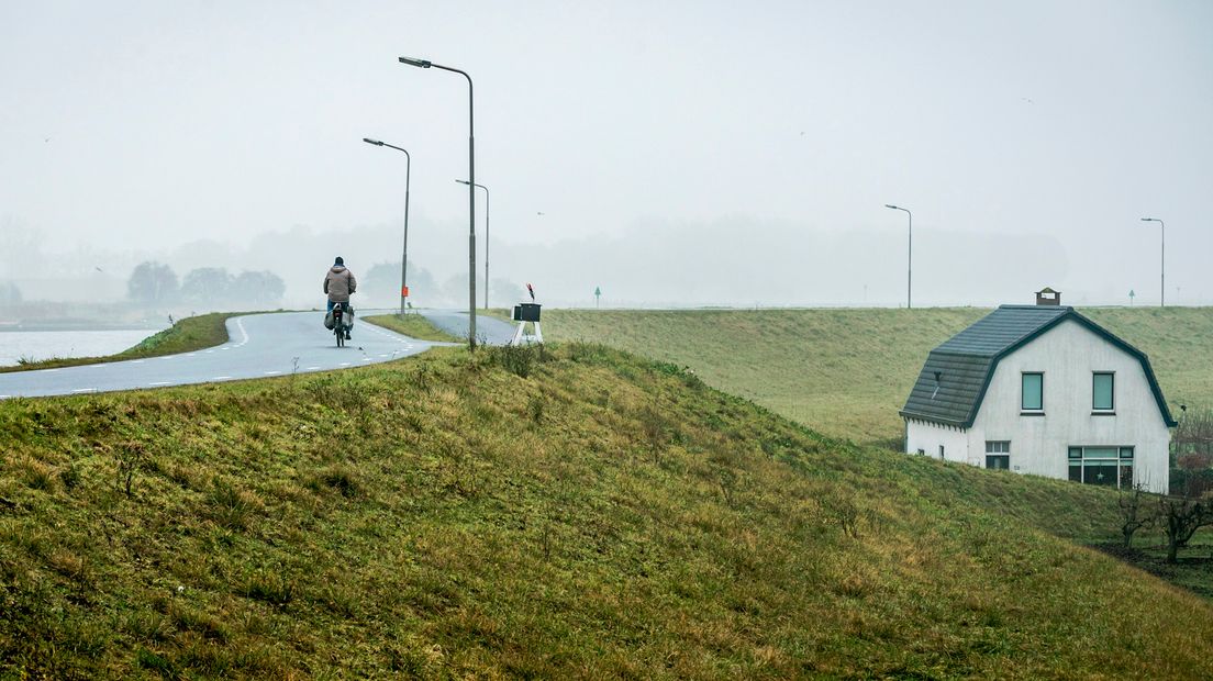 Een fietser geniet van het uitzicht over de Lek bij Hagestein.