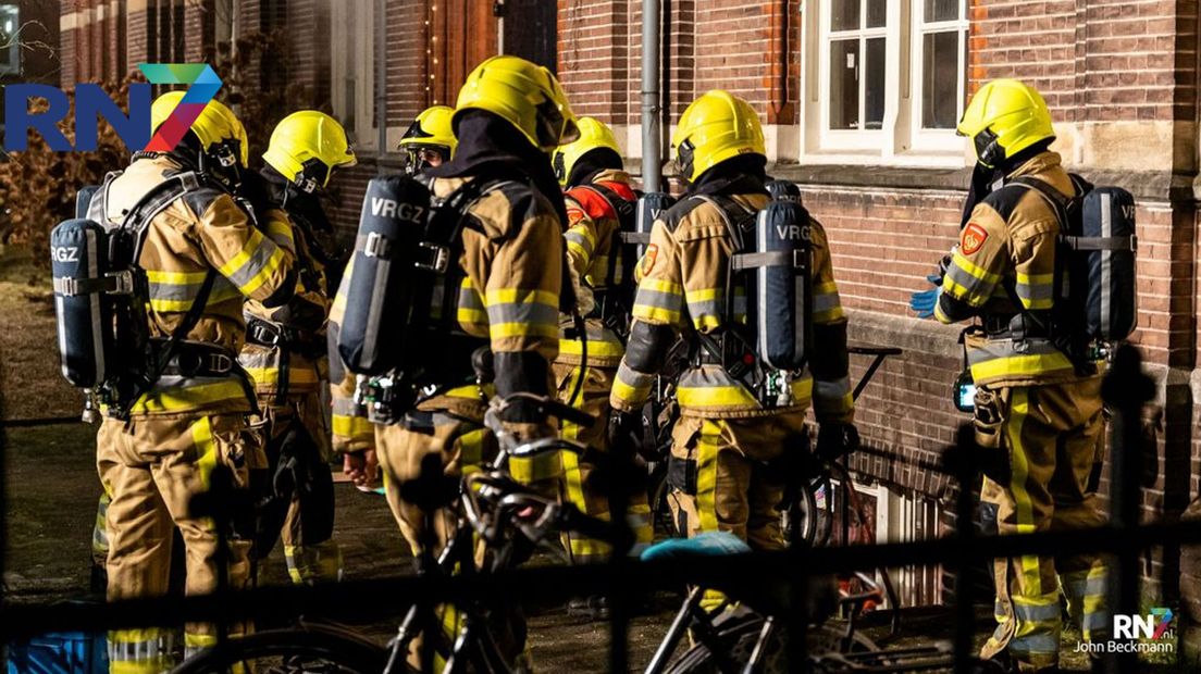 Brandweerlieden bij het pand