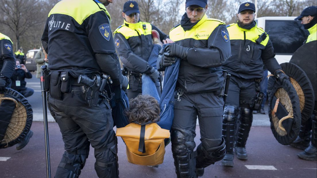 Een van de demonstranten wordt afgevoerd door de politie