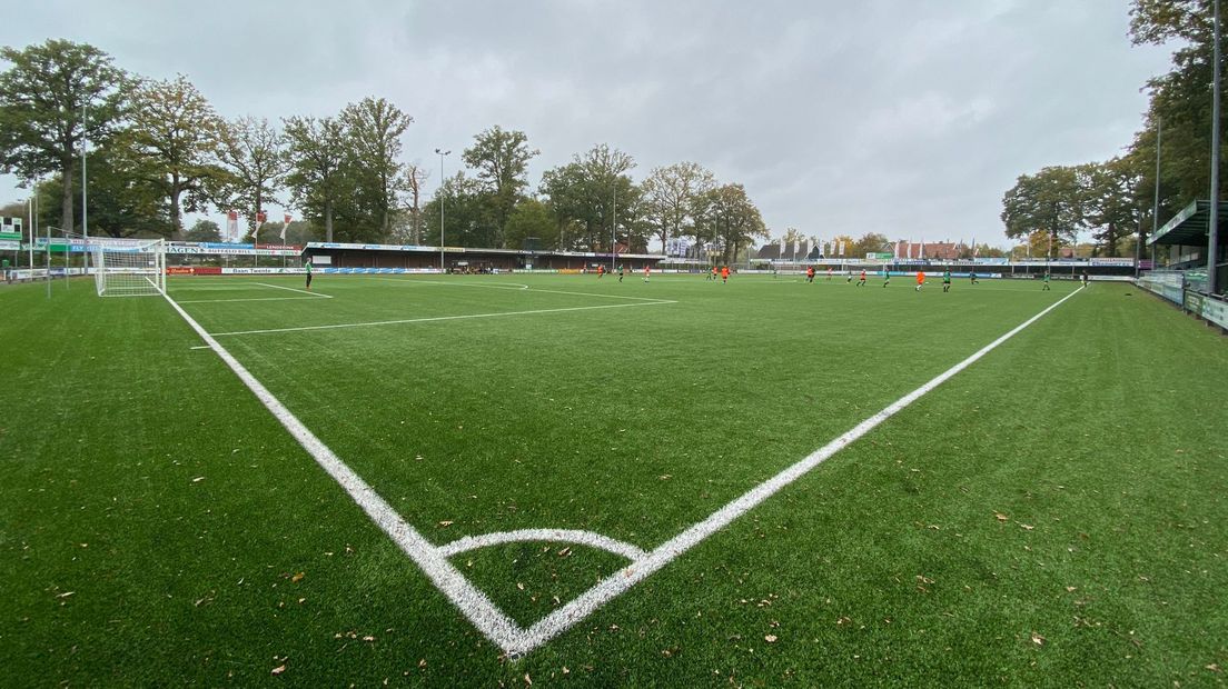 Twee elftallen, drie stewards en een scheidsrechter. Meer is er niet te zien op het sportpark