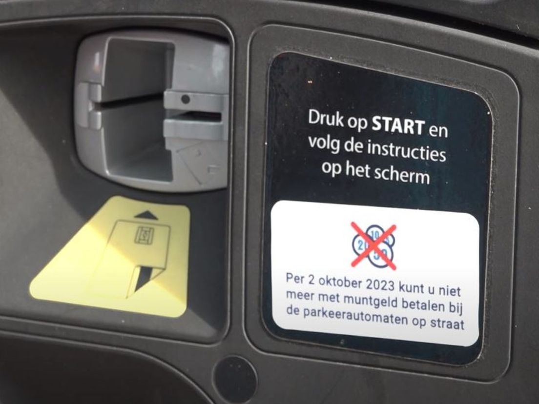Op de parkeerautomaten zijn stickers geplakt om aan te geven dat betalen met muntgeld niet meer kan