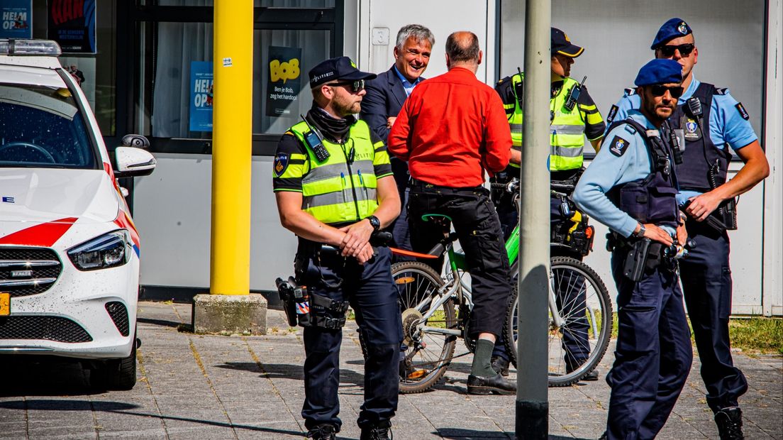 Agenten en politieauto's en Koninklijke Marechaussee voor het politiebureau aan de Molenweg in Ter Apel