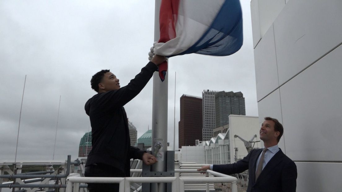 Arend van der Lely hijst de vlag op het stadhuis.