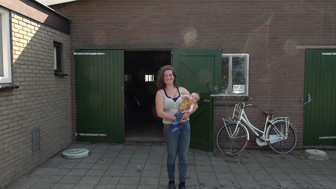 Eline van Baalen met zoontje Jelle voor hun boerderij, die binnen 500 meter van de geplande radar ligt