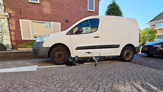 Fiets onder bestelwagen: vrouw komt er met een zeer been vanaf
