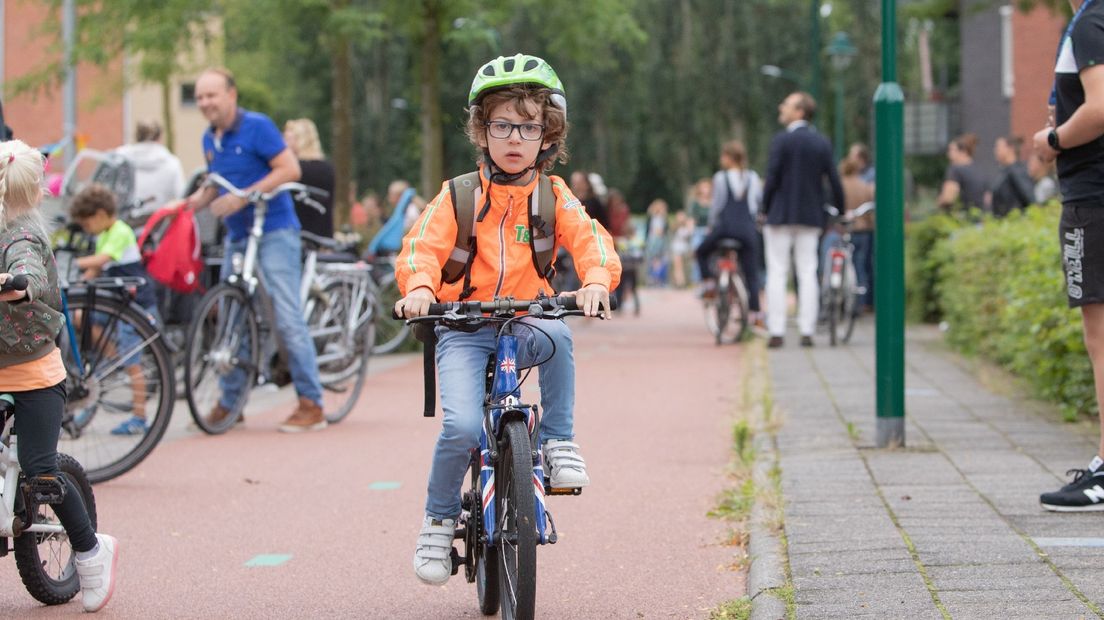 Een jongetje draagt een fietshelm op weg naar school