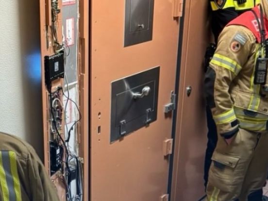 De brandweer lukt het om de deur te forceren