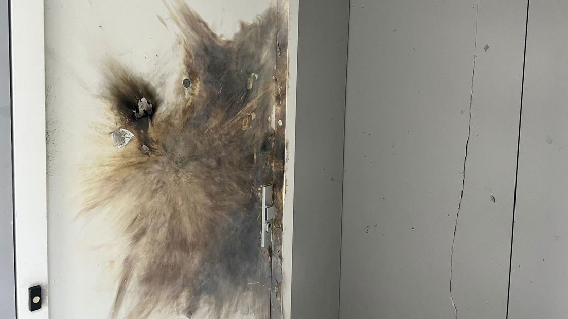 De voordeur van de woning raakte door de explosie flink beschadigd