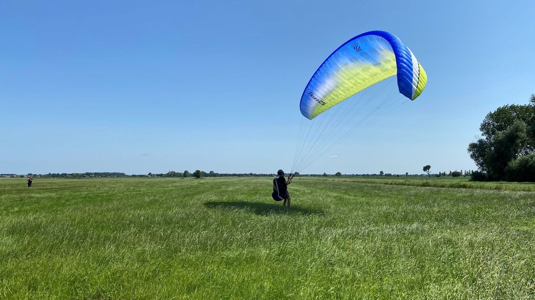 In het weiland, even verderop, zijn paragliders aan het oefenen. "Het mooiste is om te vliegen in de bergen, maar dit is ook gaaf." Ze komen de lucht in met een stevige kabel.