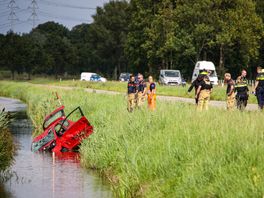 Auto over de kop in water, leven bestuurder gered door omstanders