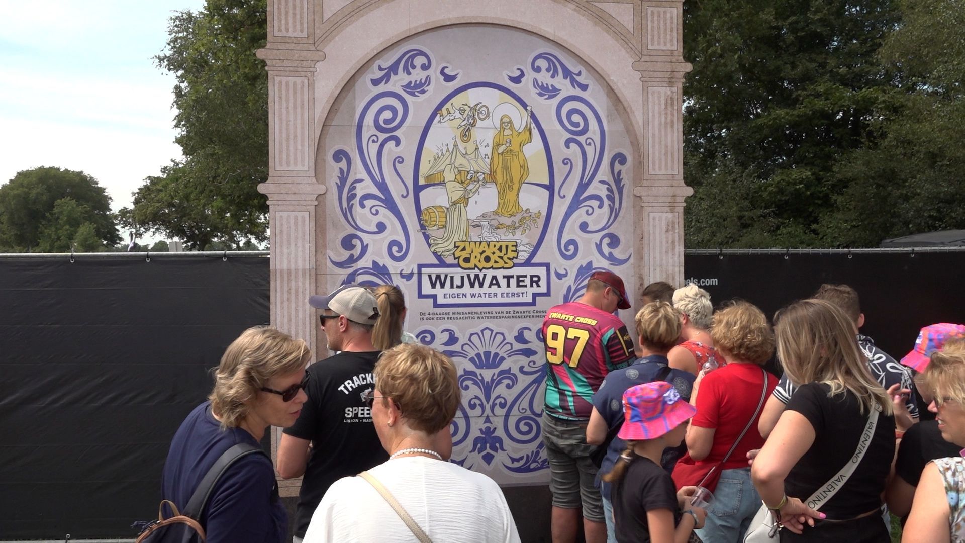 Bezoekers van de Zwarte Cross tappen water dat komt uit de grond van het festivalterrein.