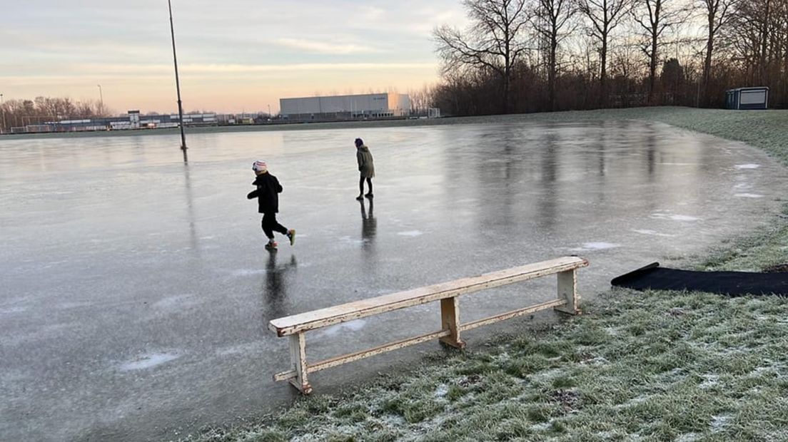 Kinderen testen het ijs op de baan van Loppersum