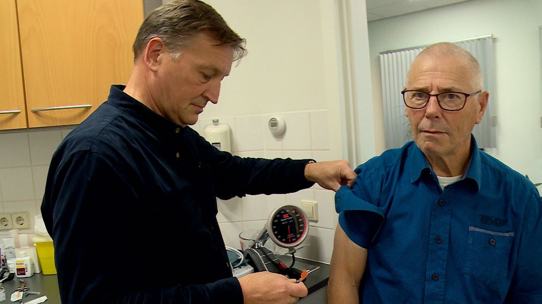 Dokter John Schmeitz uit Goes geeft een patiënt de griepprik