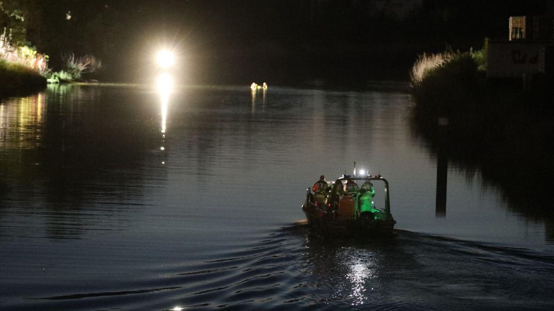 Een duikteam zoekt per boot naar mensen die te water zijn geraakt.