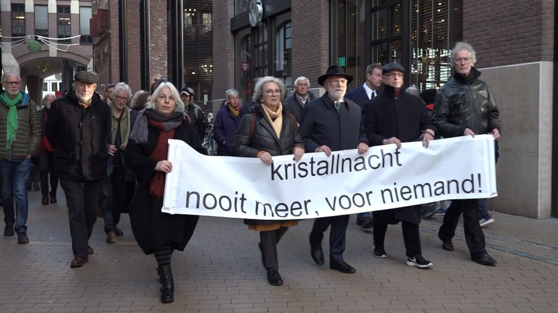Lopers dragen een spandoek met de tekst: 'Kristallnacht. Nooit meer, voor niemand!'