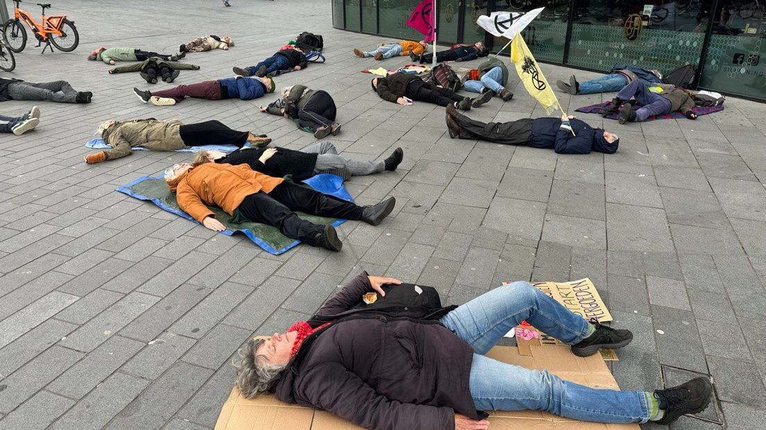 Actievoerders van XR liggen als 'klimaatdoden' op de grond uit protest.