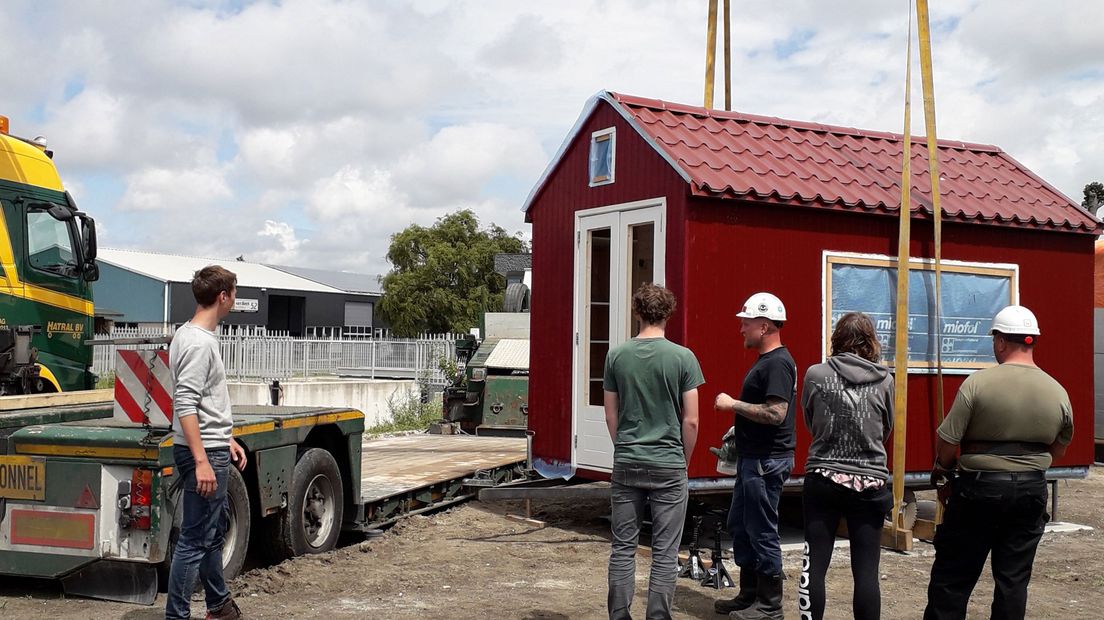 Een tiny house wordt op zijn plek getakeld.