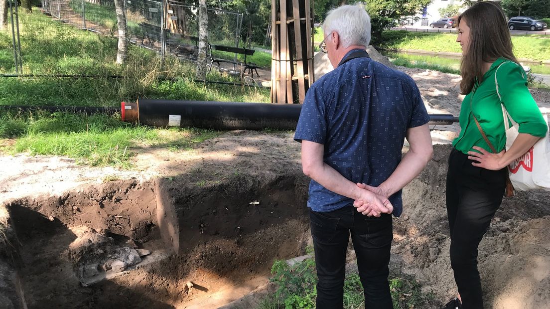 Omstanders bekijken de oude muur.