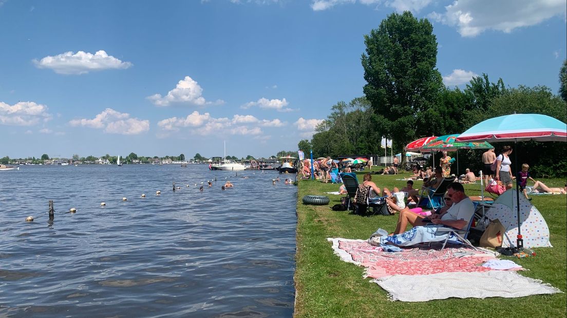 Badgasten genieten van de warmte bij de Strook