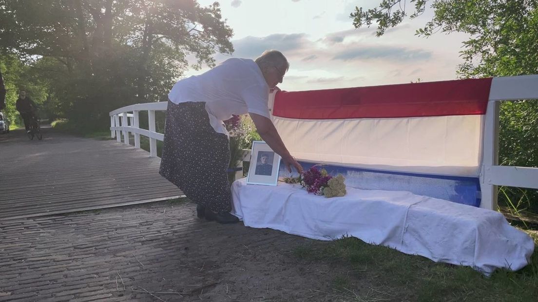 Froukje Zeilemaker-Hovenkamp legt bloemen bij de onthulde plaquette ter ere van haar neef.