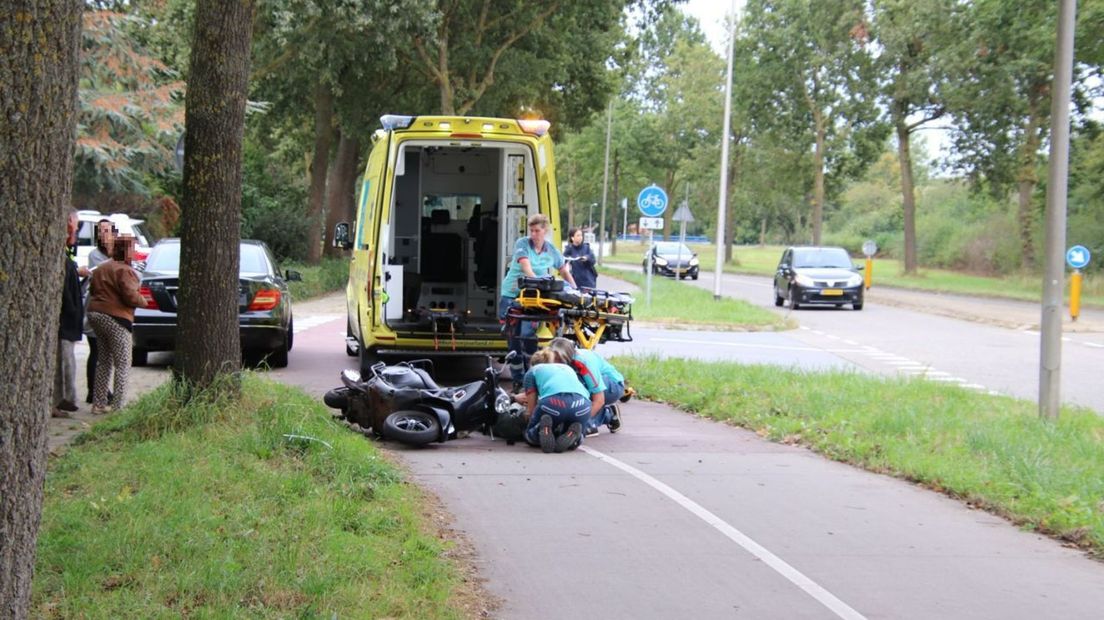 hulpverleners helpen gevallen scooterrijder