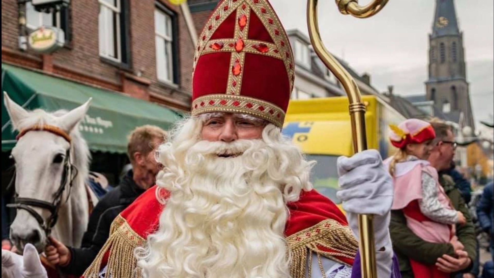 Sinterklaas tijdens de intocht door een rij van kinderen en hun ouders.