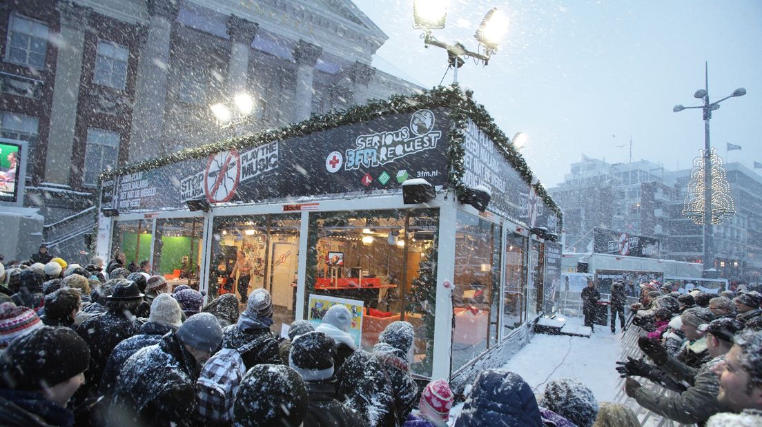 Het sneeuwt flink als mensen zich verzamelen om het Glazen Huis in december 2009 op de Grote Markt in Groningen