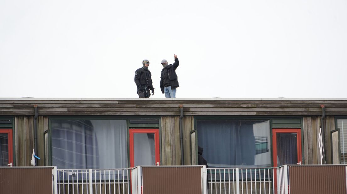 Politieagenten op het dak van het appartementencomplex