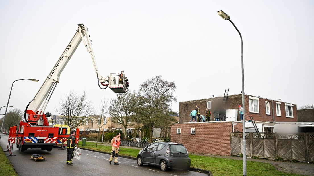 De hulpdiensten helpen het slachtoffer op het dak in Hoogezand