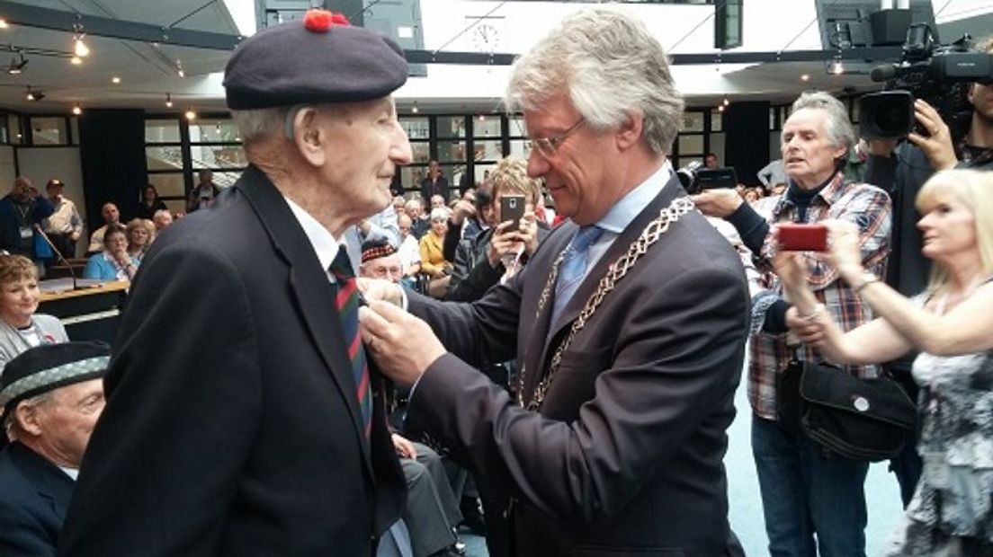Veteraan krijgt eremedaille opgespeld.