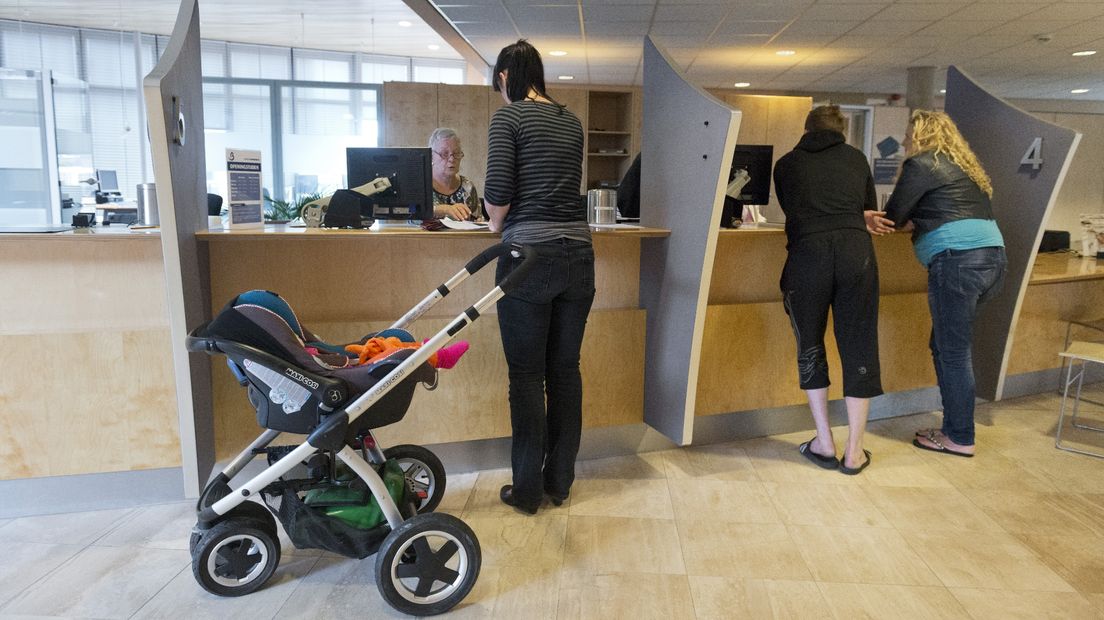 Een vrouw laat haar kind inschrijven in het gemeentehuis