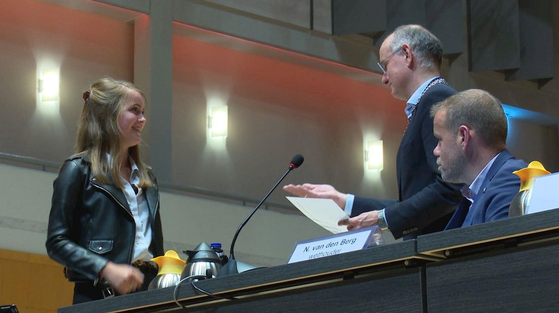 Myrthe van der Houwen overhandigt de handtekening aan burgemeester Onno van Veldhuizen