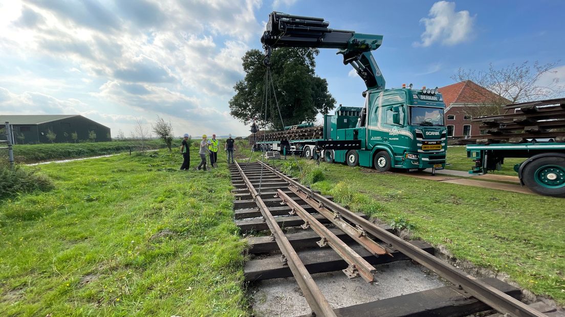 De treinrails worden in de tuin van Jos van der Veen geplaatst