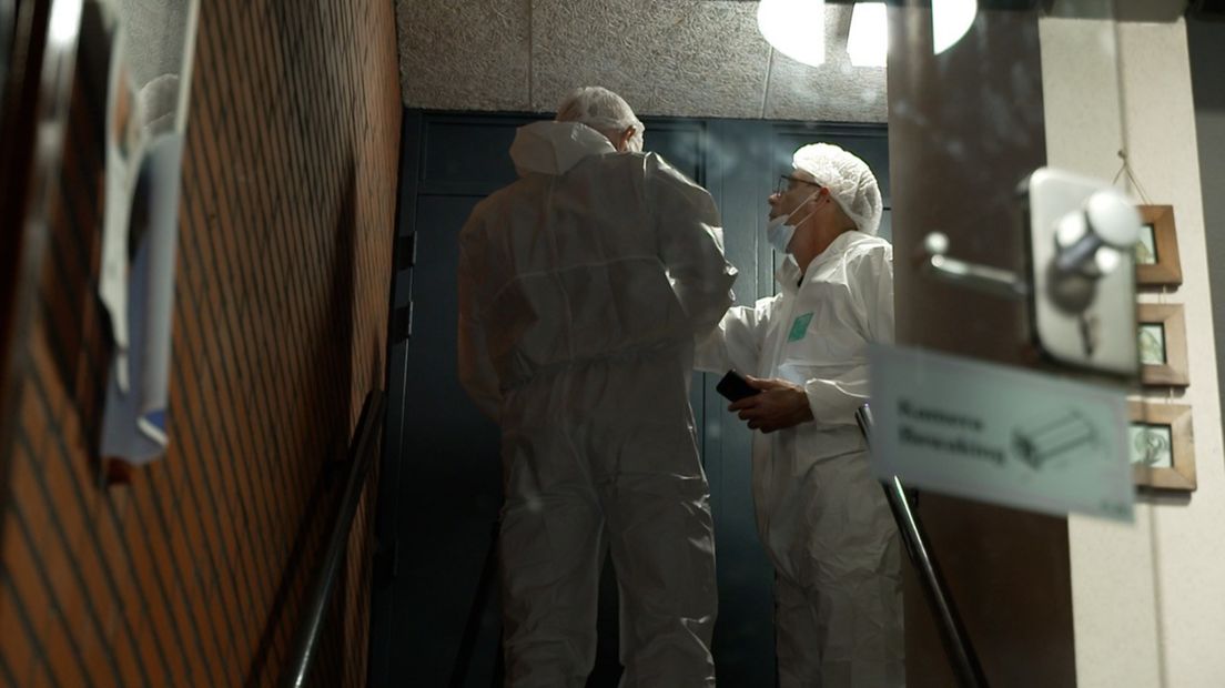 Forensisch rechercheurs doorzoeken de woning