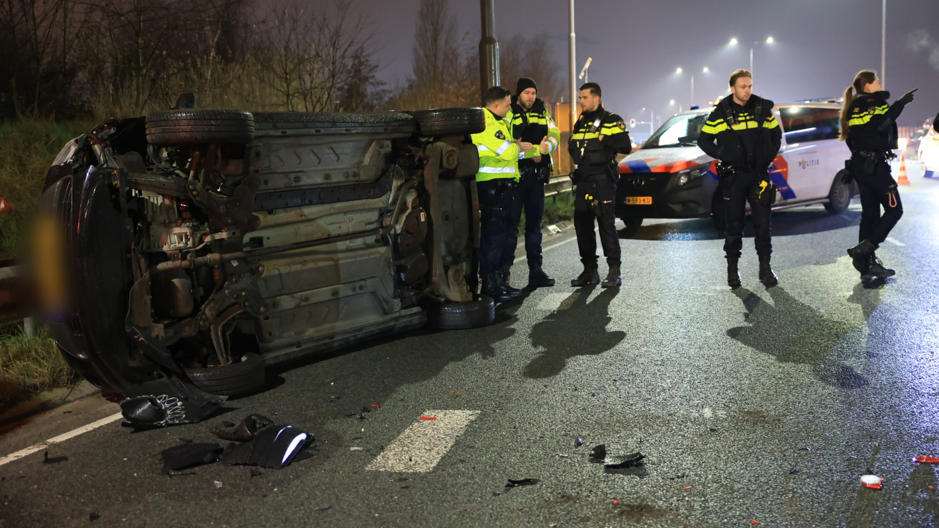 Auto op zijn kant na ongeluk, lange file richting snelweg.