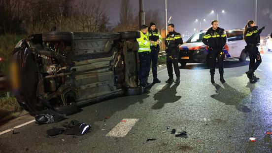 Auto op zijn kant na ongeluk, lange file richting snelweg. Auto op zijn kant na ongeluk, lange file richting snelweg.