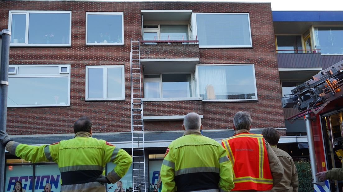 Brandweerlieden bij het appartement van de buitengesloten vrouw