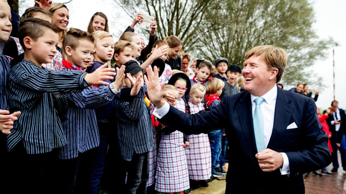Koning begroet kinderen in klederdracht in de gemeente Bunschoten.
