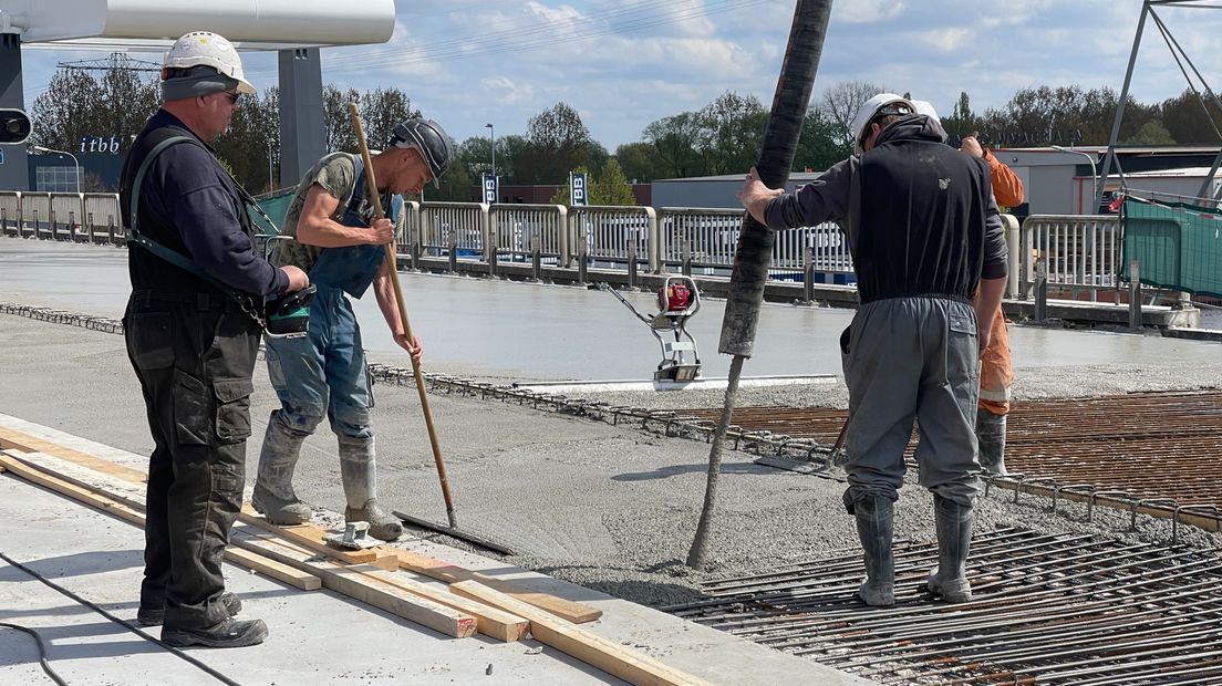 Bouwvakkers begeleiden de betonstort