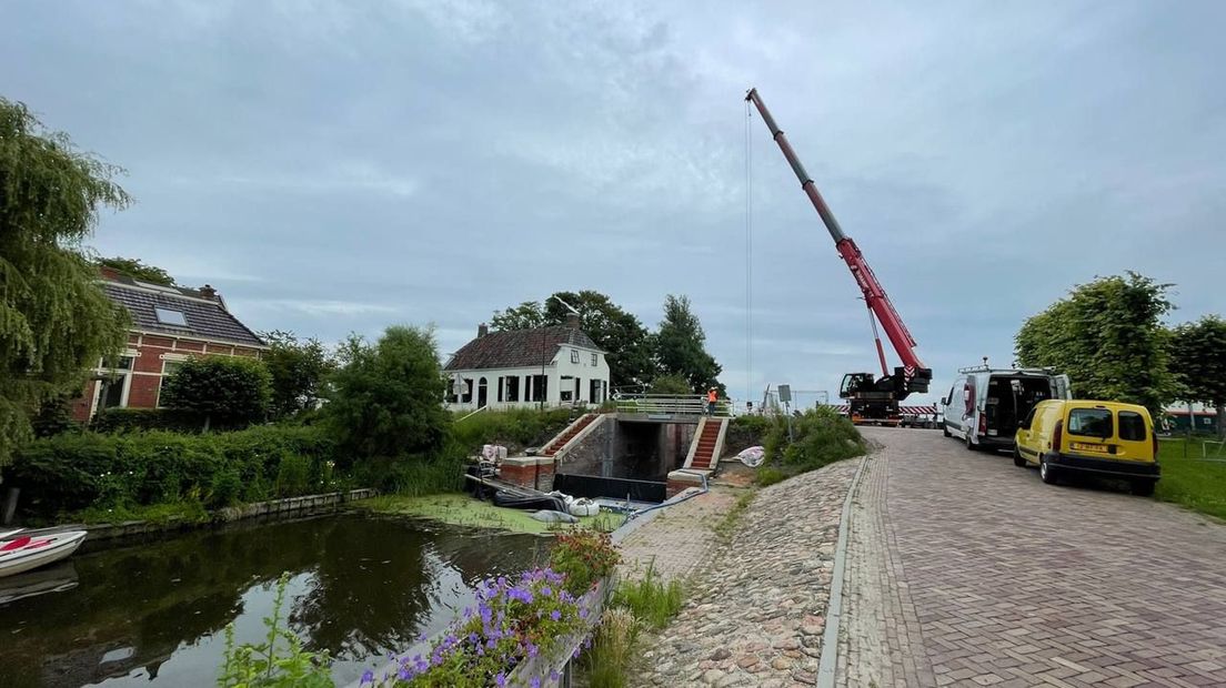 De kraan tilt de afsluiter op de juiste plek