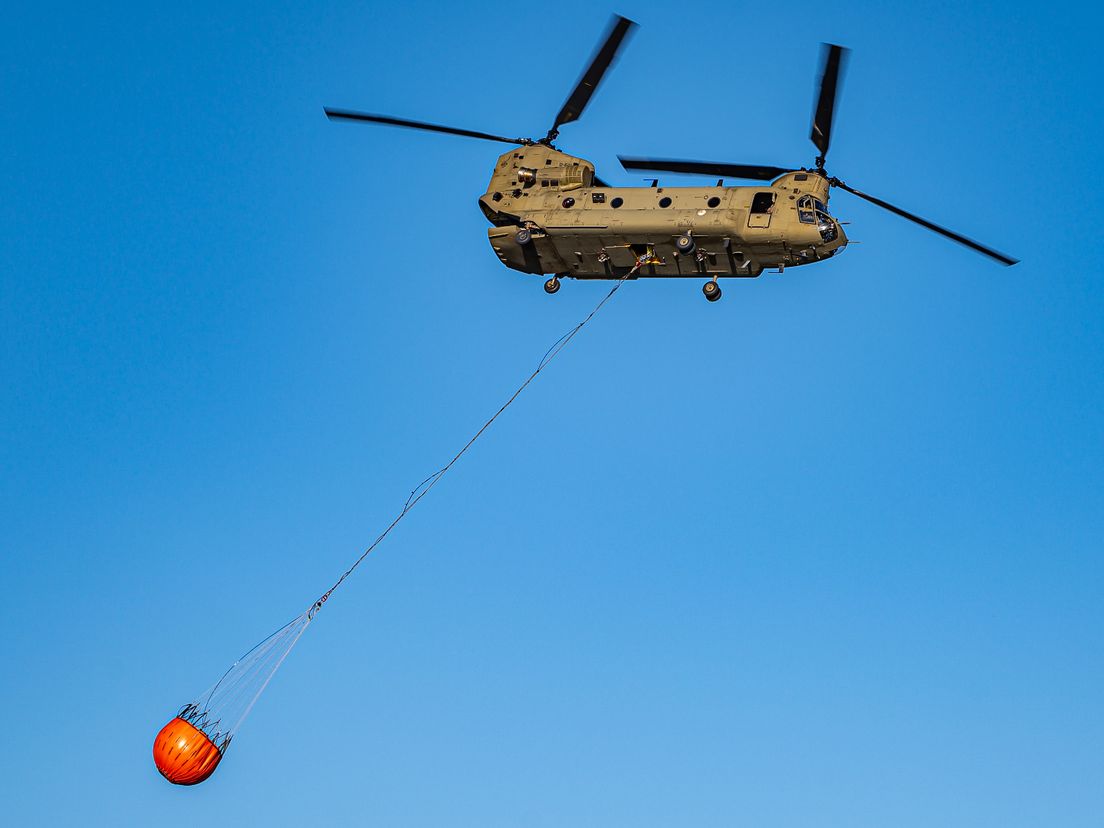 Een chinook van defensie hielp met blussen vanuit de lucht.