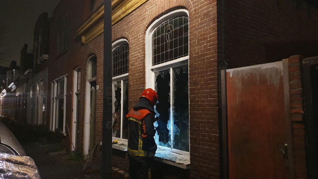 Een brandweerman staat voor het huis waar brand woedde