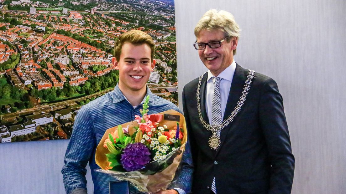 De 18-jarige Milan ten Broek ontvangt de onderscheiding uit handen van burgemeester Lucas Bolsius