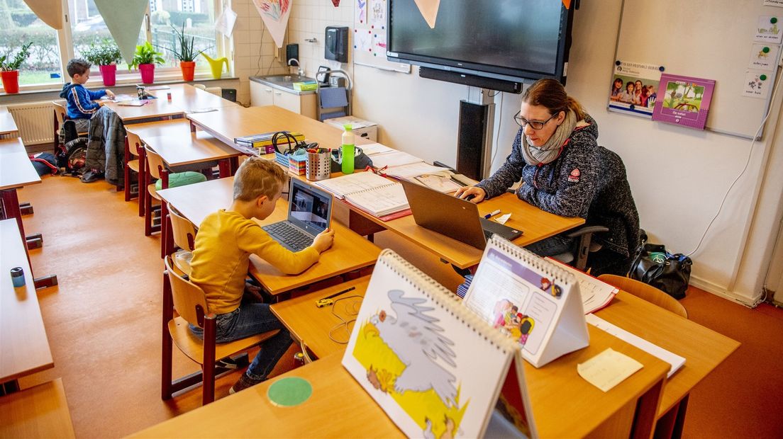 Op basisschool Duiveland geeft een docent digitaal les. Leerlingen met ouders die een cruciaal beroep hebben mogen wel fysiek aanwezig zijn.