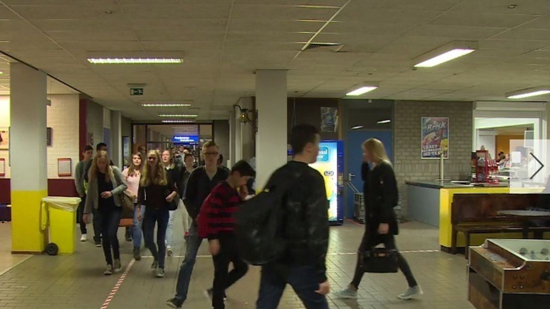 Leerlingen lopen door de gang van middelbare school