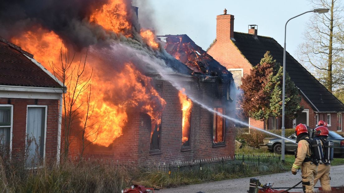 De brandweer bestrijdt de brand in de woning in Borgsweer.