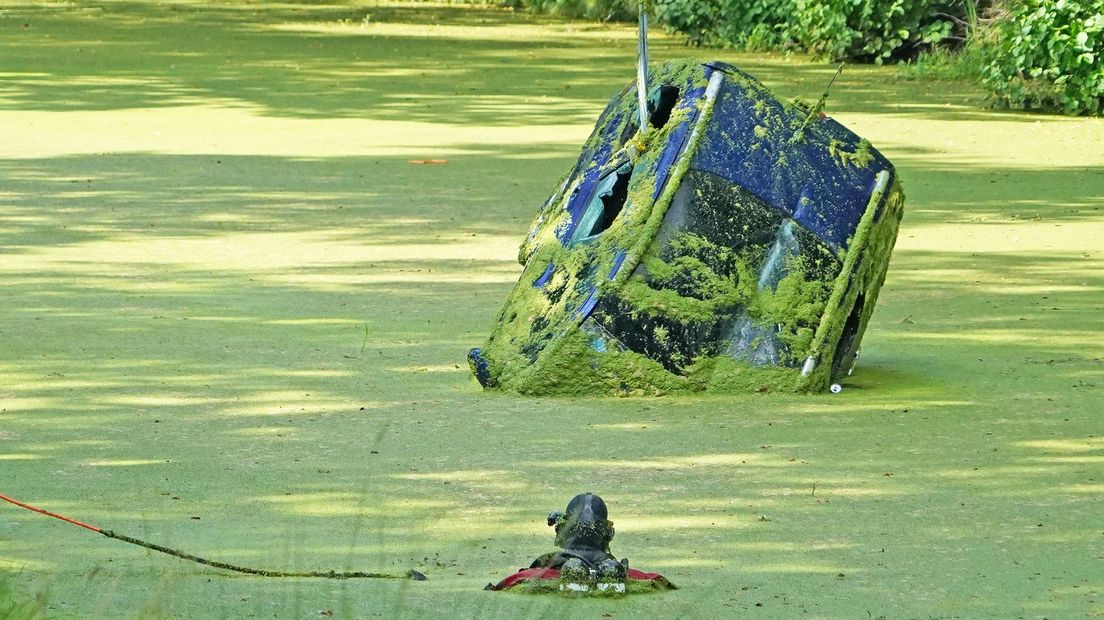 De brandweer takelt de auto uit het water