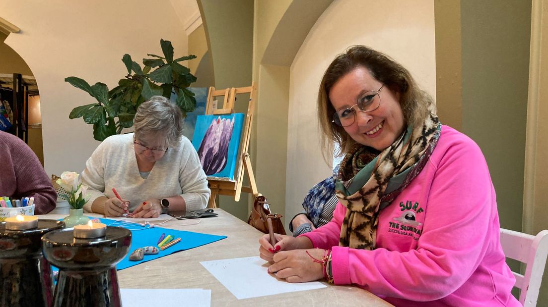 Saskia van Westrienen in actie tijdens een workshop 'happy stones' schilderen